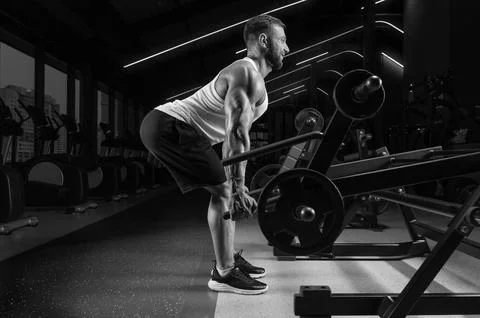 Handsome young man pumps his back in a special machine. Deadlifting. Fitnes.. Stock Photos
