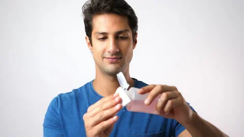 Handsome young man put moisturizer lotion on cotton pad, apply on face Stock Footage 137443266