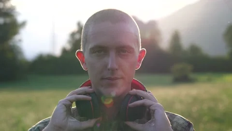 Handsome Young Man Putting On His Headphones at Sunset, Slow Motion Video stock 137722862