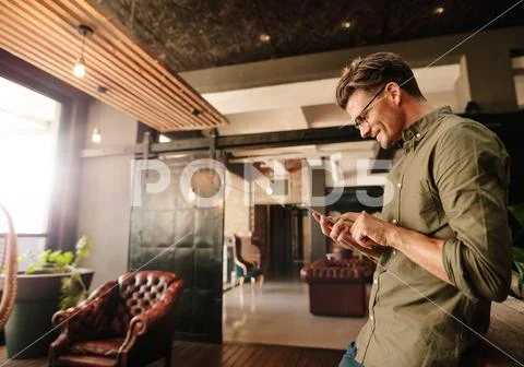 Handsome young man reading text message Stock Photos