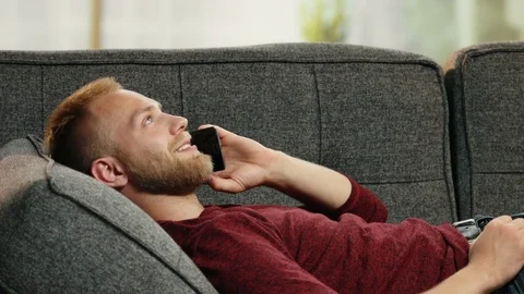 Handsome young man relaxing on sofa while calling his girlfriend Video stock 78041109