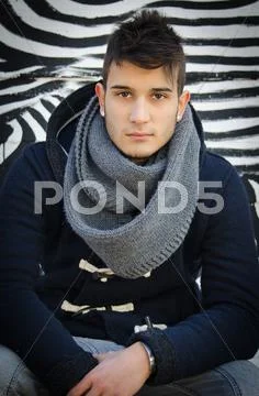 Handsome young man sitting against zebra striped design Stock Photos