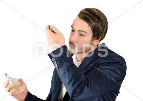 Handsome young man smelling perfume or cologne Stock Photos
