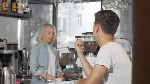Handsome young man smiling to the camera while enjoying his coffee at the cafe Stock Footage 116898108