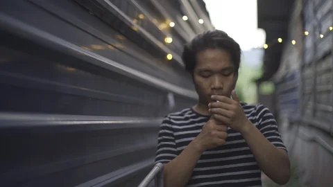 A handsome young man smoking cigarette at outside Stock Footage 93108932