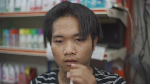 A handsome young man smoking cigarette at indoor Stock Footage 93108959