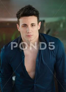 Handsome young man standing with open shirt showing torso Stock Photos