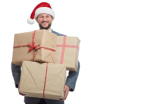 Handsome young man in a suit wearing Christmas hat holding a pile of presents Stock Photos