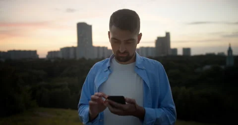 Handsome young man, is super connected to friends and family chats and texts on Stock Footage 157644380