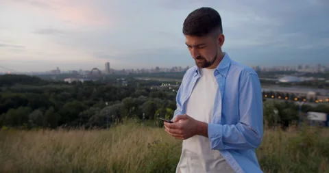 Handsome young man, is super connected to friends and family chats and texts on Stock Footage 157644445