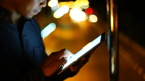 Handsome, young man with tablet computer in city at night Stock Footage 63540085