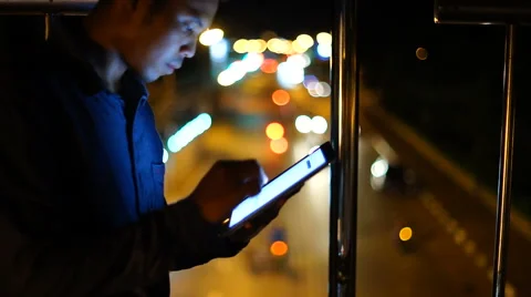 Handsome, young man with tablet computer in city at night Stock Footage 63540632