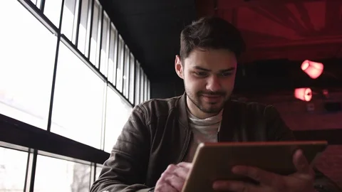 Handsome young man with tablet computer in cafe, feeling happy Stock Footage 78577203