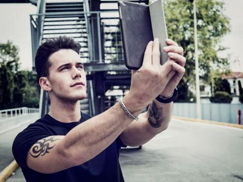 Handsome young man with tablet PC in city Stock Photos