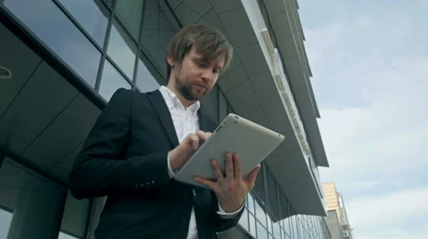 Handsome young man with tablet in the streets near office Stock Footage 64698845