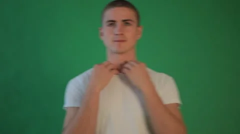Handsome Young Man Takes His T-Shirt Off Against Chroma Key Background Stock Footage 22251653