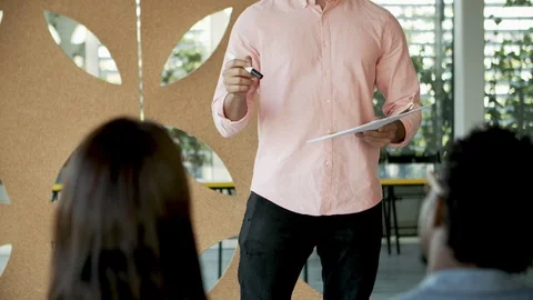 Handsome young man talking to colleagues Stock Footage 119976242