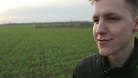 Handsome young man talking in the green field Video stock 106316417
