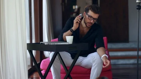 Handsome young man talking on the mobile phone and smiling while playing with Stock-Footage 85524422