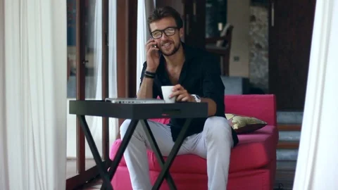 Handsome young man talking on the mobile phone and smiling while sitting Stock-Footage 85524525