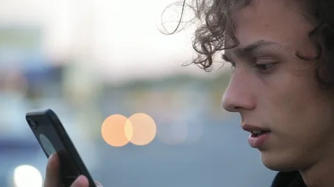 Handsome young man talking in video chat on the phone on the street Stock Footage 97409458