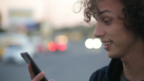 Handsome young man talking in video chat on the phone on the street Stock Footage 97409481
