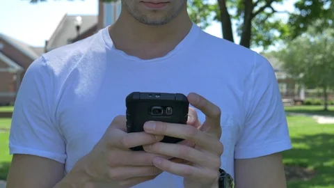 Handsome young man texting on a smartphone 스톡 동영상 75658202