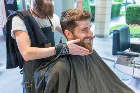 Handsome young man thinking of a different shape for his beard Stock Photos