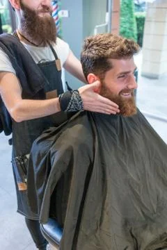 Handsome young man thinking of a different shape for his beard Stock Photos