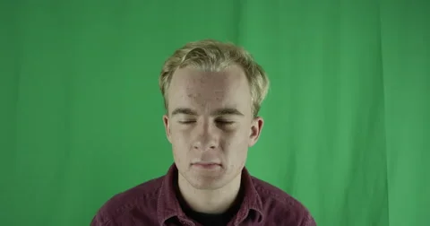 Handsome young man thinks and remembers on a greenscreen Vidéo 59720183