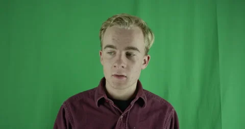 Handsome young man tries to remember something, shrugs on a greenscreen Vidéo 59720462