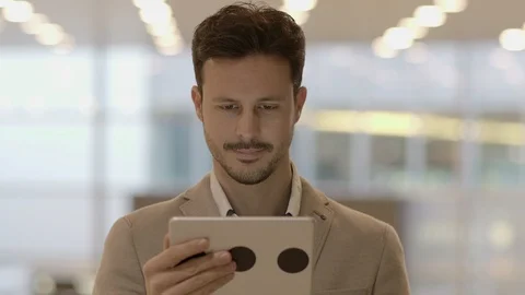 Handsome Young Man Using Digital Tablet Computer Screen Browsing the Internet Stock Footage 87739411