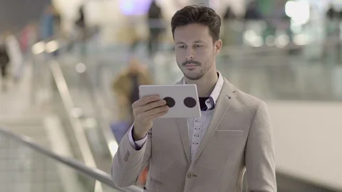 Handsome Young Man Using Digital Tablet Computer Screen Browsing the Internet Stock Footage 87739978