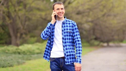 Handsome Young Man Using his Mobile Device while Walking in Street.  Stock Footage 110899386