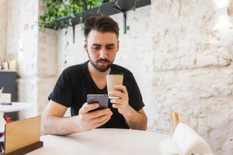Handsome, young man using his mobile phone in a public area Stock Photos