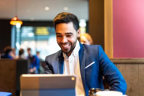 Handsome young man using laptop indoors. Stock Photos
