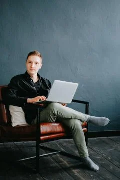 Handsome young man using laptop computer at home. Stock Photos