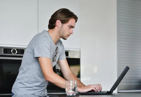 Handsome young man using a laptop on an out of focus background. Stock Photos