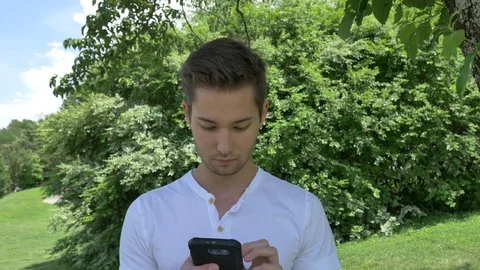 Handsome young man using a smart phone 스톡 동영상 76220477