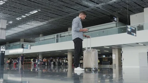 Handsome Young Man Using Smartphone And Working at The Airport While Waiting His Stock Footage 76373584