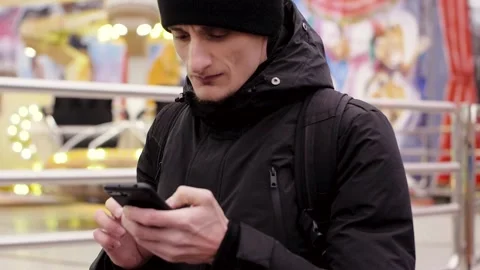 Handsome young man using smartphone in the city, amusement park at the evening Stock Footage 135940055