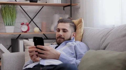 Handsome young man using smartphone and laughing. Happy smiling hipster man with Stock Footage 181502555