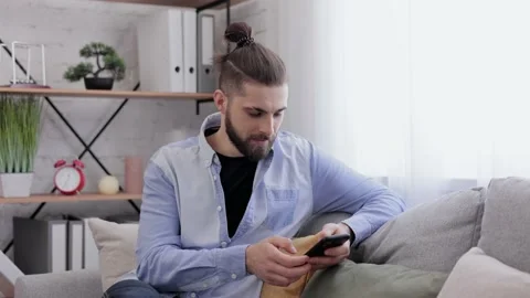 Handsome young man using smartphone and laughing. Happy smiling hipster man with Stock Footage 181502675