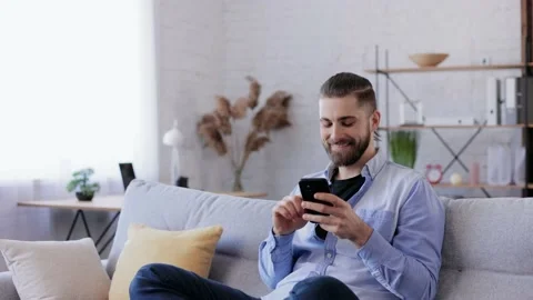 Handsome young man using smartphone and laughing. Happy smiling hipster man with Stock Footage 181503683