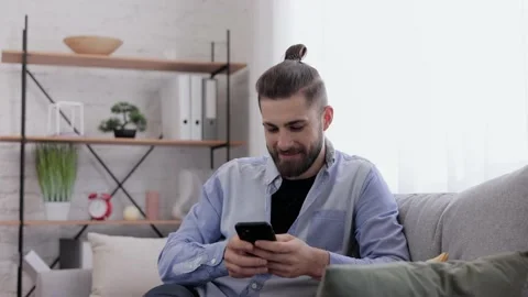 Handsome young man using smartphone and laughing. Happy smiling hipster man with Stock Footage 203796590