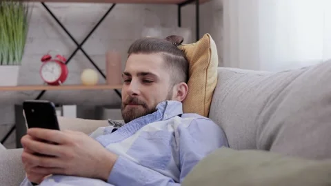 Handsome young man using smartphone and laughing. Happy smiling hipster man with Stock Footage 203796625