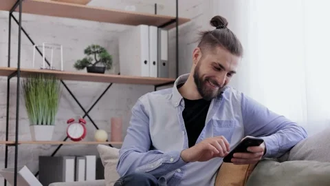 Handsome young man using smartphone and laughing. Happy smiling hipster man with Stock Footage 234149752