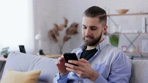 Handsome young man using smartphone and laughing. Happy smiling hipster man with Stock Footage 234149871