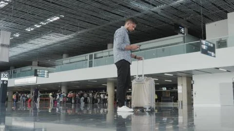 Handsome Young Man Using Smartphone And Working at The Airport While Waiting His Stock Photos