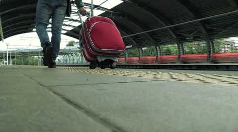Handsome young man walking along a platform at a train station Stock Footage 34273136